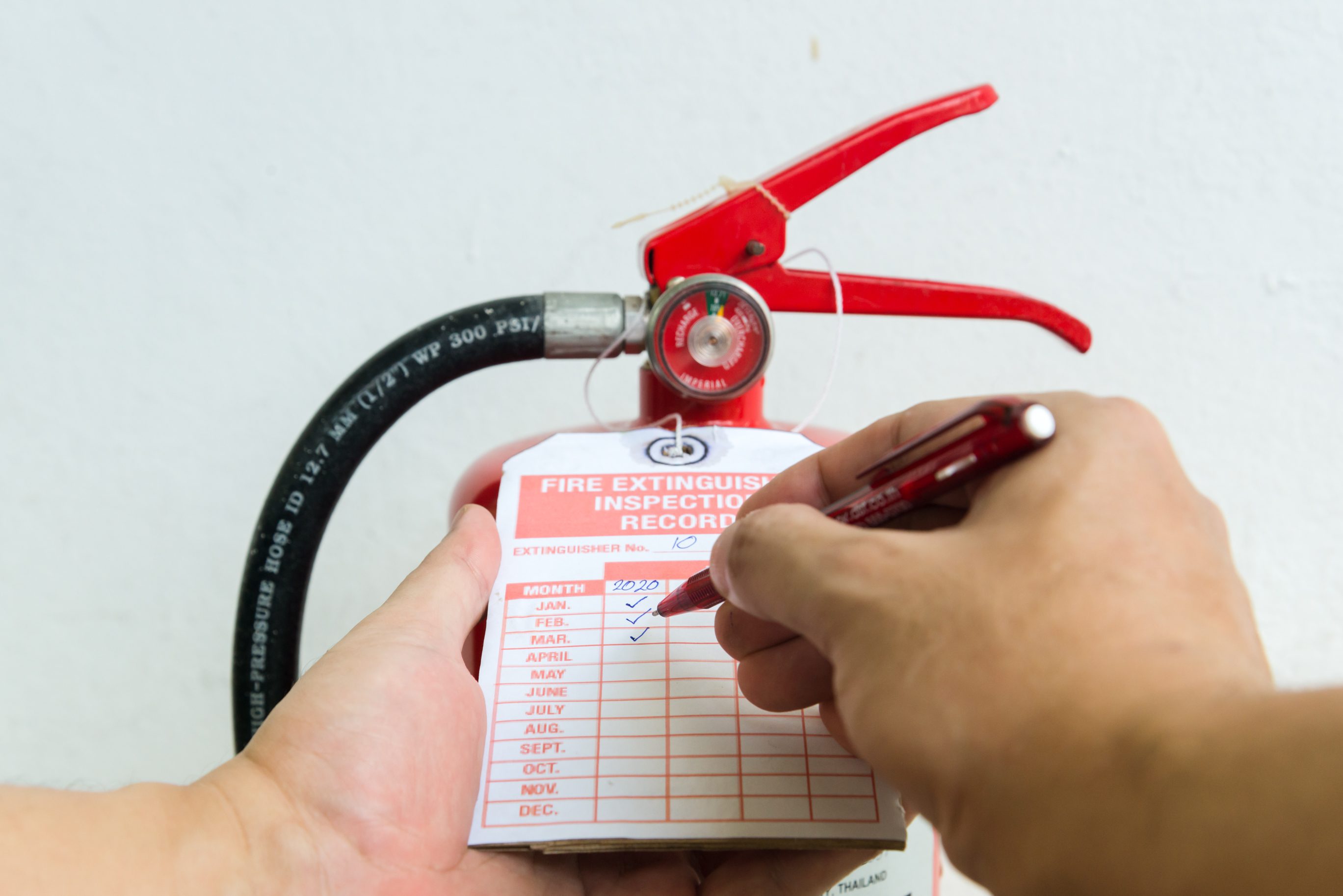 Fire extinguisher inspection record being checked.