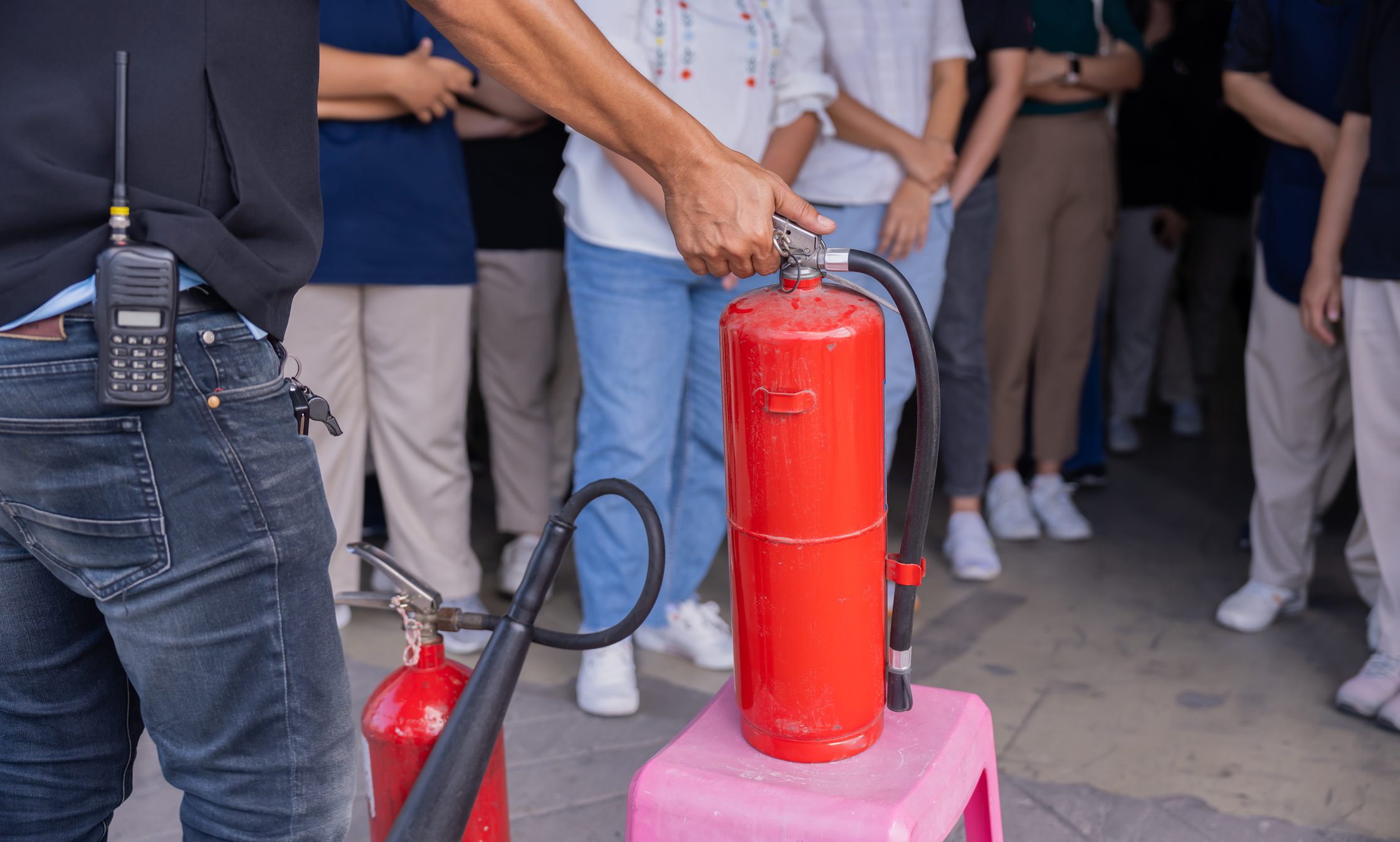 Person holding fire extinguisher during demonstration.