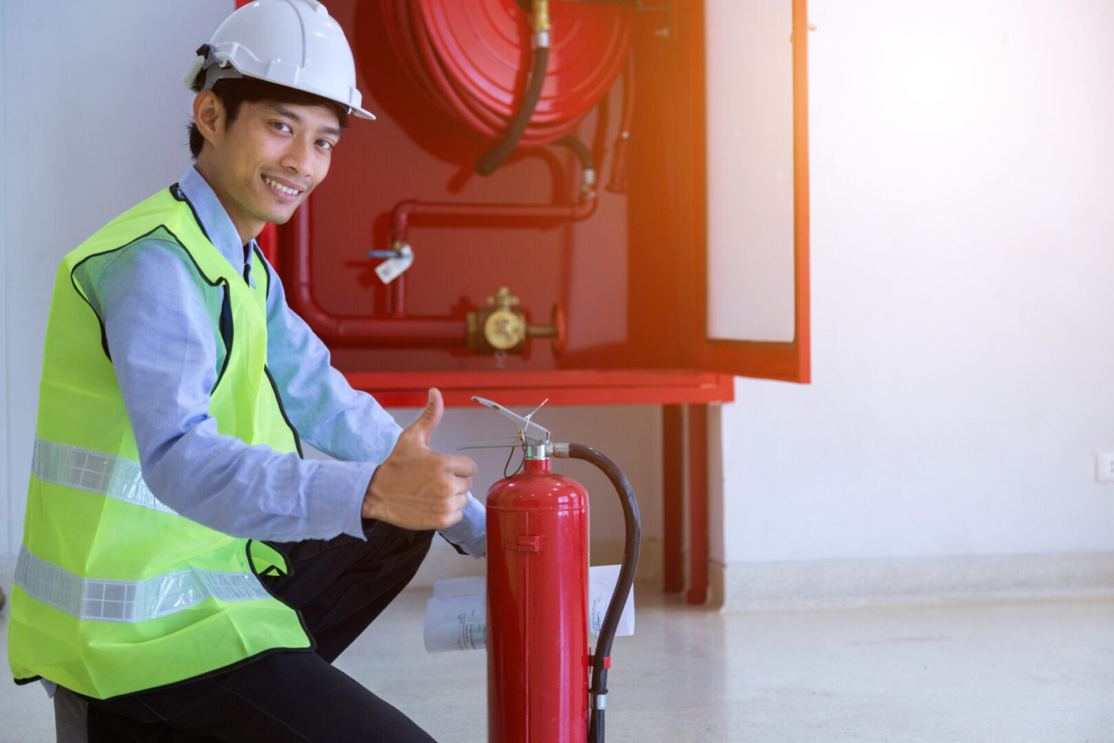 Man in safety gear with fire extinguisher.