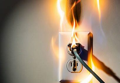 Electrical wall outlet and plug engulfed in flame
